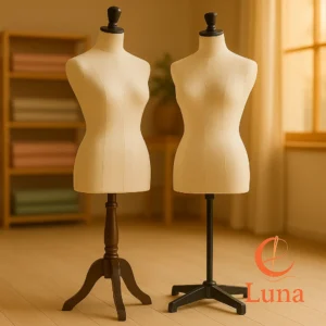 Comparativa visual de un maniquí de costura con base de trípode de madera y otro con base de 4 patas metálica, situados en un taller de costura profesional.